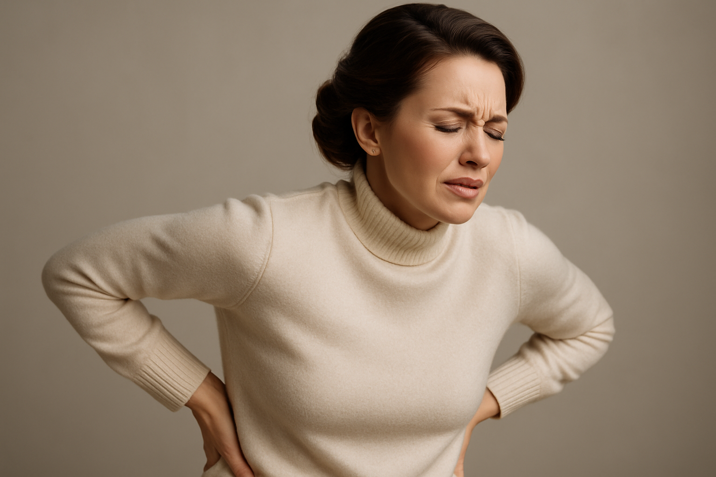 a realistic image of woman holding their lower back with her hands, wincing in pain, face tense an grimacing, showing kidney stone pain. focus facial expression. the overall mood should feel like a luxury advertisement, elegant, confident and effortlessly sophisticated.